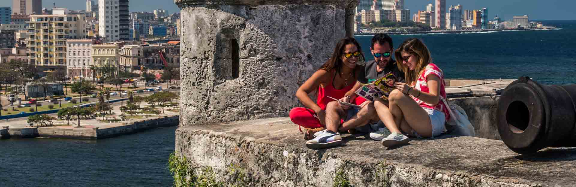 Tres-jóvenes-disfrutan-de-le-lectura-en-el-castillo-Los-Tres-Reyes-del-Morro-la-Habana-CubaTravel
